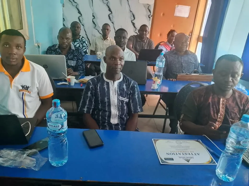 Enseignants en salle de formation avec ordinateurs portables et attestation Educom Succès