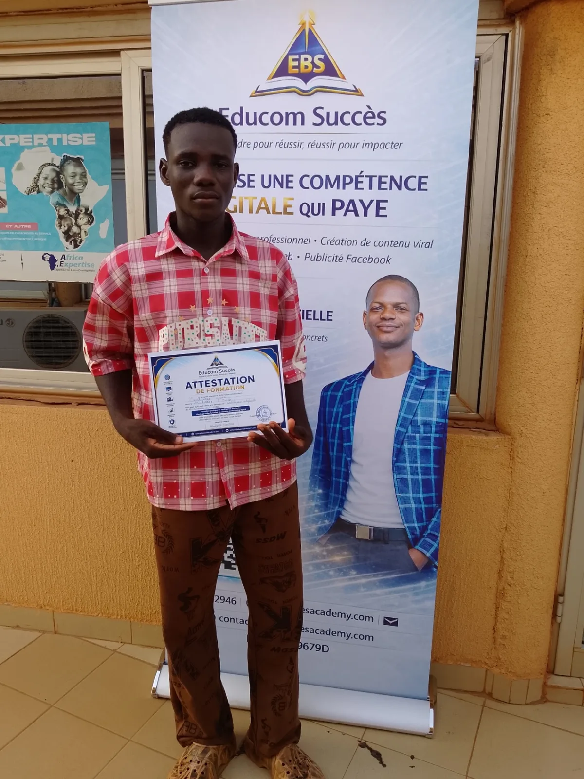 Jeune apprenant présentant son attestation de formation Educom Succès