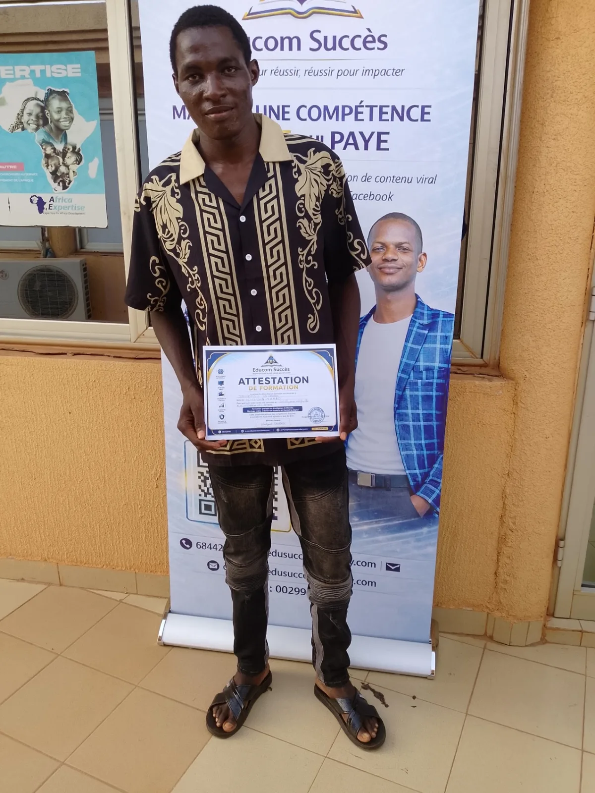 Apprenant posant avec son attestation de formation Educom Succès
